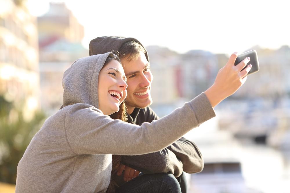 young couple with hoodies on smiling | invisalign allentown pa