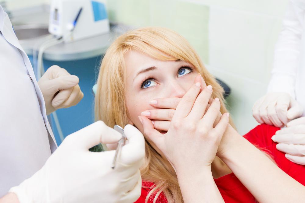 woman holding face in fear | sedation dentistry allentown p