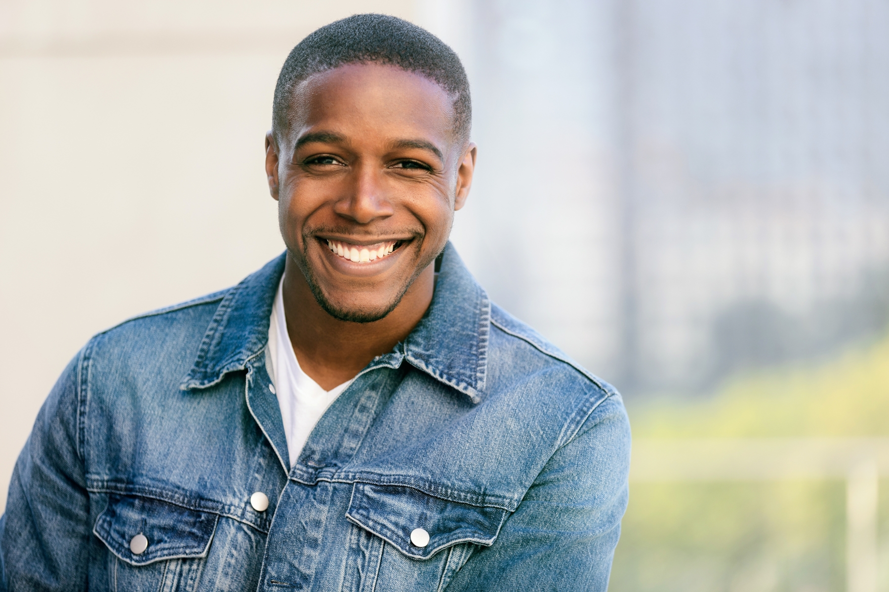man in jean jacket smiling with bright teeth from teeth whitening in allentown