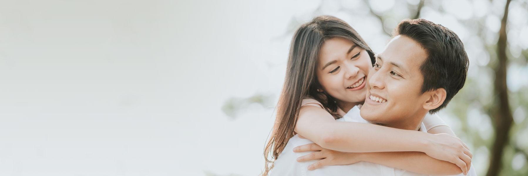 young asian couple hugging & smiling l tooth extraction allentown
