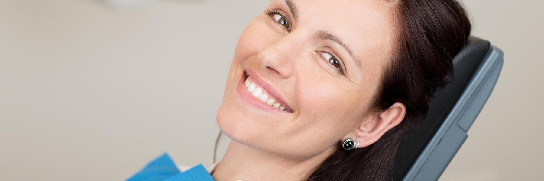 woman sitting in dental exam chair smiling l dentist emmaus pa