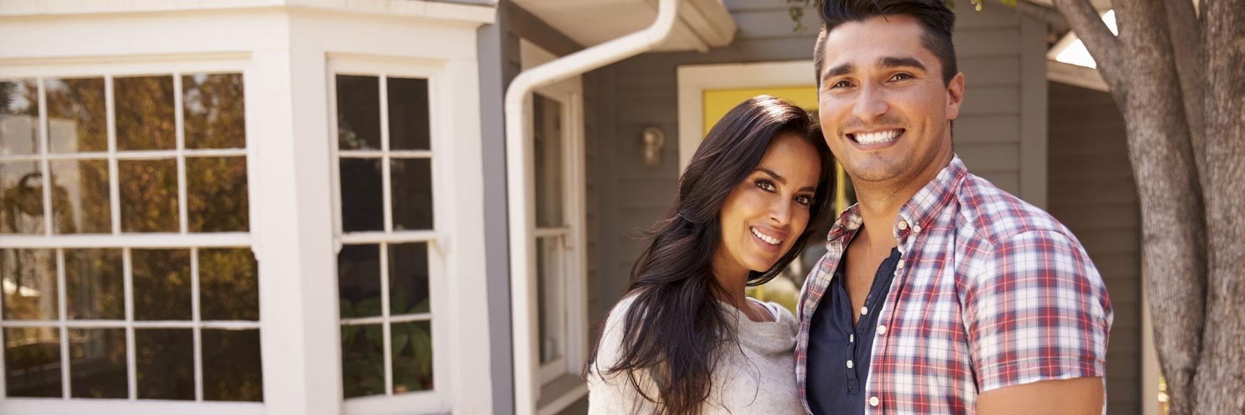 younger couple smiling by a house l best allentown dentist