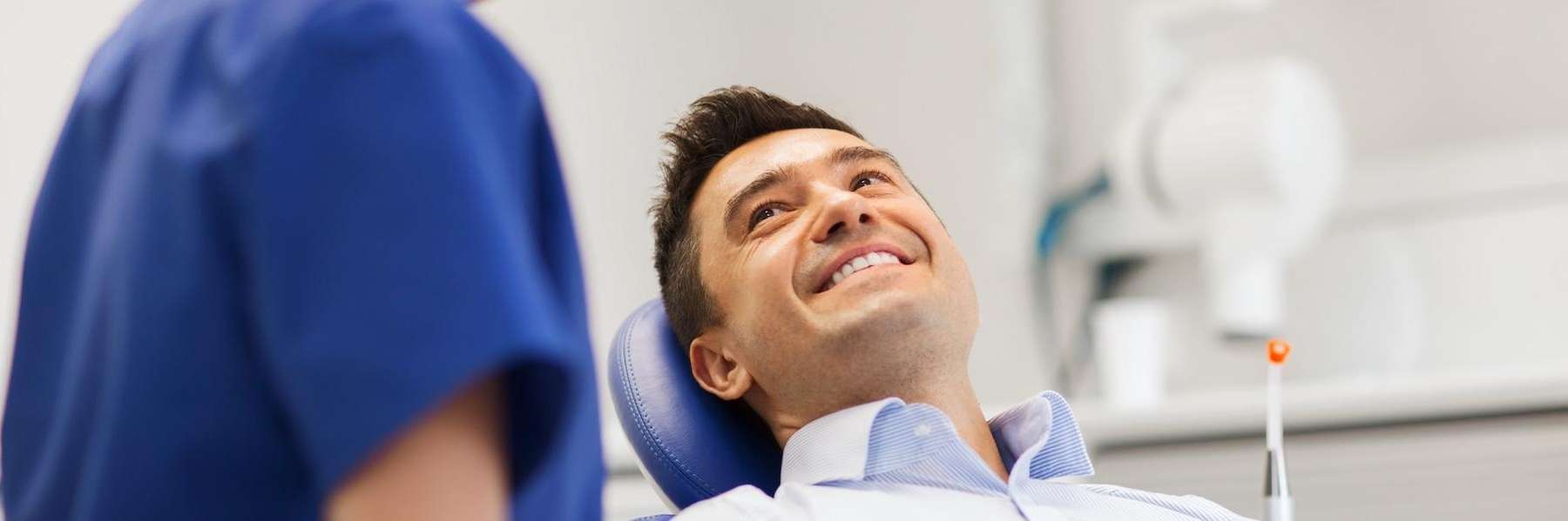 man sitting in dentist exam chair | dentist near me