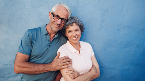 Confident older couple smiling together before a major dental treatment decision