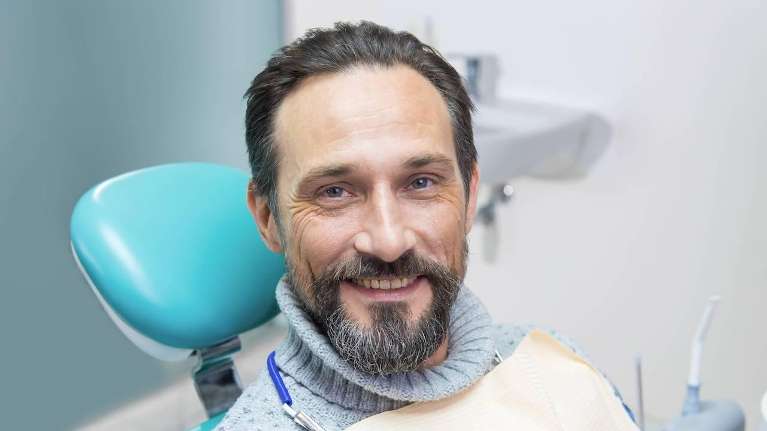 A smiling man in a dental exam room